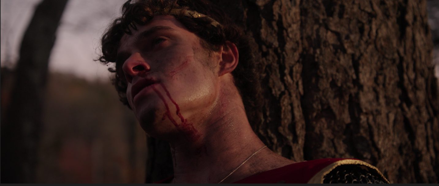 Edmund, wounded, against a tree